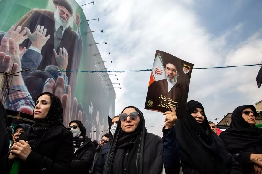 Mulheres seguram imagem do novo líder supremo do Irã, Mojtaba Khamenei, em ato em memória dos militares mortos na guerra contra EUA e Israel — Foto: Arash Khamooshi/The New York Times